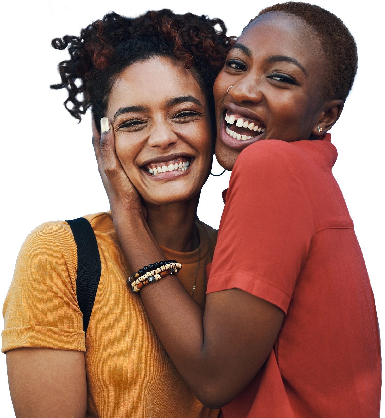 Two friends smile at the camera while they hug